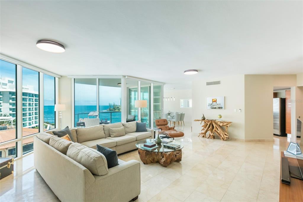 A bright living room features a beige sectional sofa, a driftwood coffee table, and ocean views — 5 MUNOZ RIVERA AVENUE UNIT 504, SAN JUAN, PR