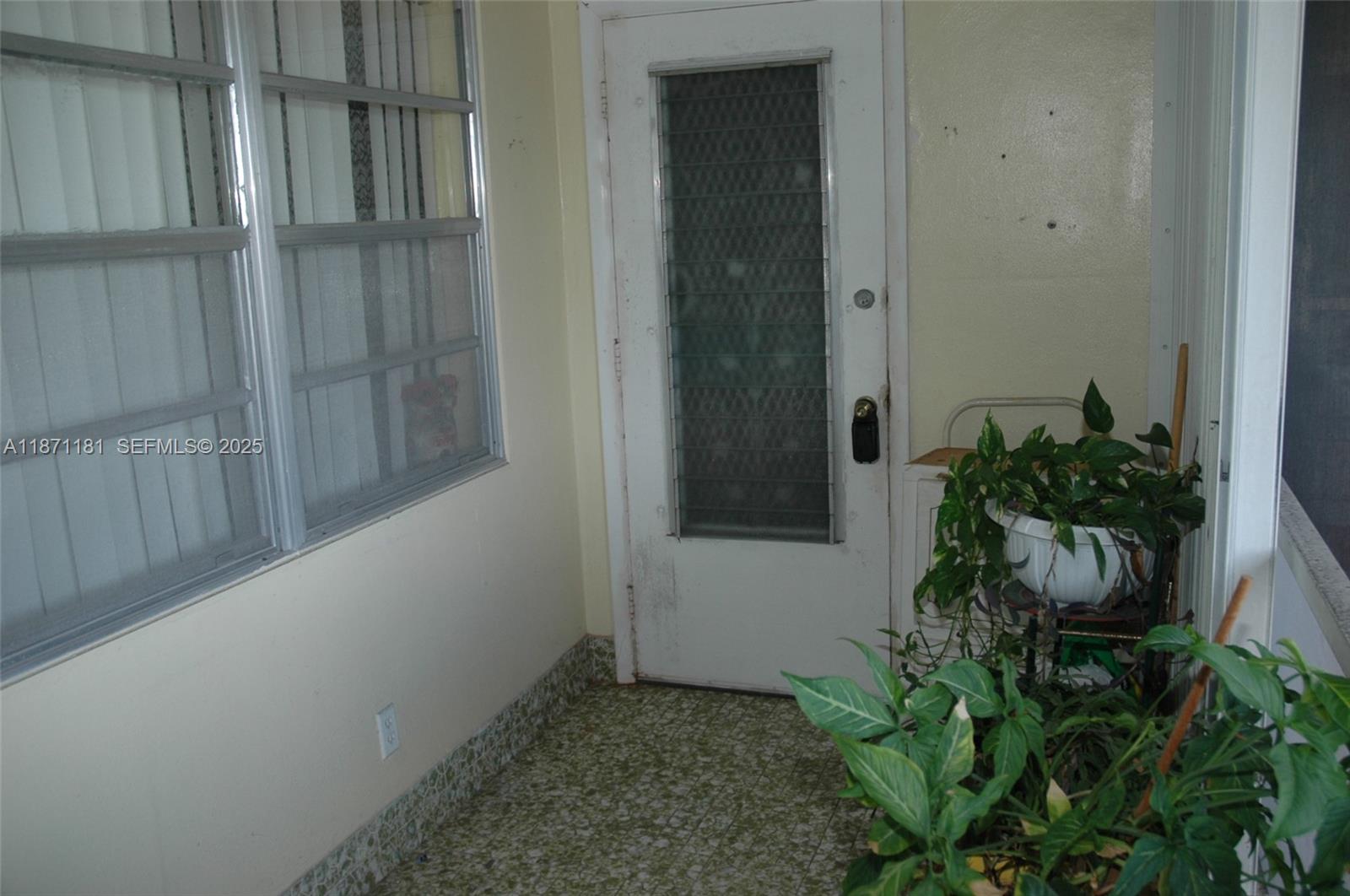 A covered porch features a white door, a large window, and several potted green plants — 5300 Washington St # Q307, Hollywood FL 33021, HOLLYWOOD, FL