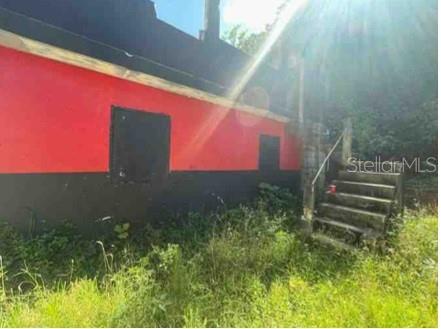 The exterior of a building features red and black painted walls and concrete stairs — Km. 5.0 ,PR-486, ABRA HONDA ROAD, CAMUY, PR
