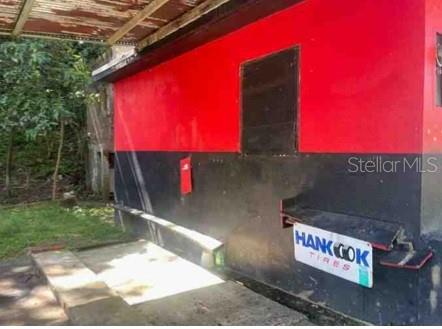 A red and black exterior wall features a small window and a Hankook Tires sign — Km. 5.0 ,PR-486, ABRA HONDA ROAD, CAMUY, PR