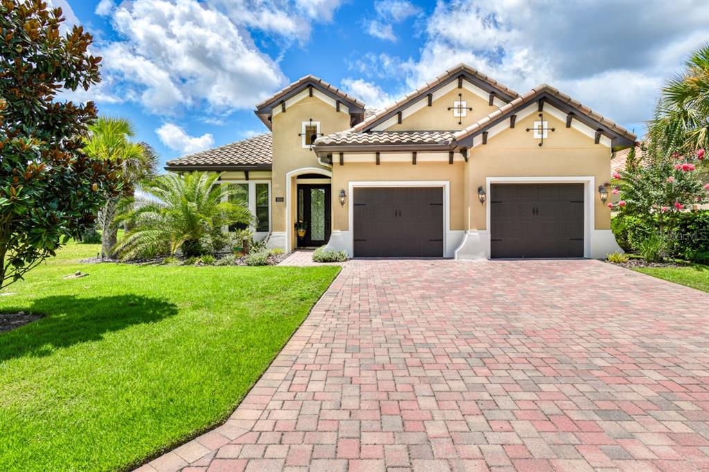 A single-story house with a paved driveway, two garage doors, and a tiled roof — 169 ASPEN WAY, PALM COAST, FL