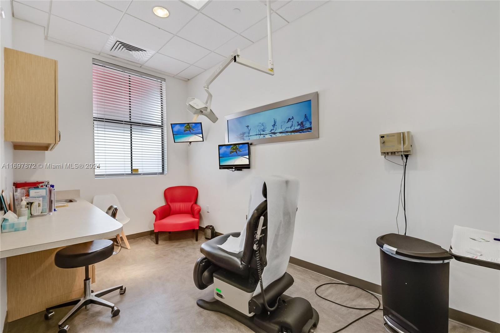 A clinical examination room features a patient chair, medical equipment, and a red accent chair — 6705 Red Rd # 518, Coral Gables FL 33143, CORAL GABLES, FL