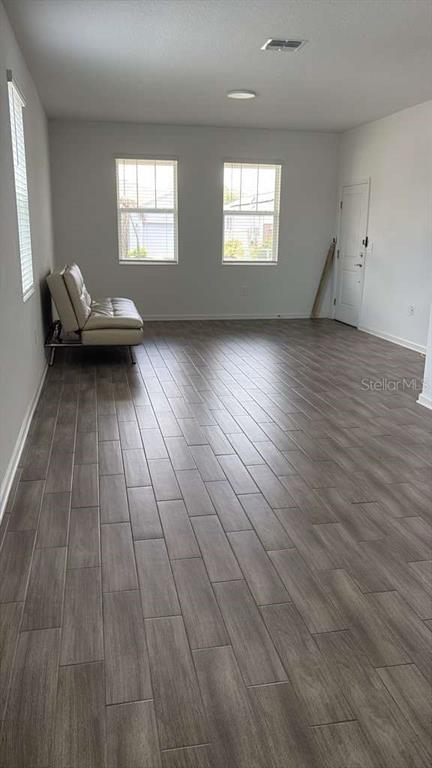 A living room features gray wood-look tile flooring, two windows, and a beige sofa — 6267 LAKEPINE STREET, ST CLOUD, FL