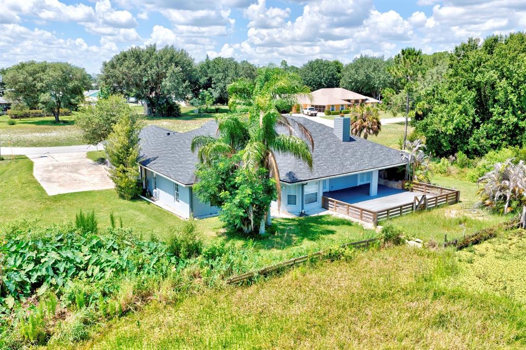 An aerial view of a single-story house with a deck and a large palm tree — 110 GATES AVENUE, LAKE PLACID, FL