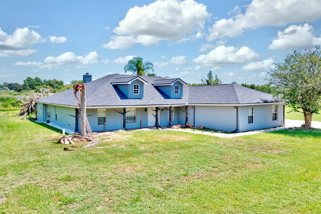 A single-story house with a gray exterior, dark roof, and two dormer windows — 110 GATES AVENUE, LAKE PLACID, FL