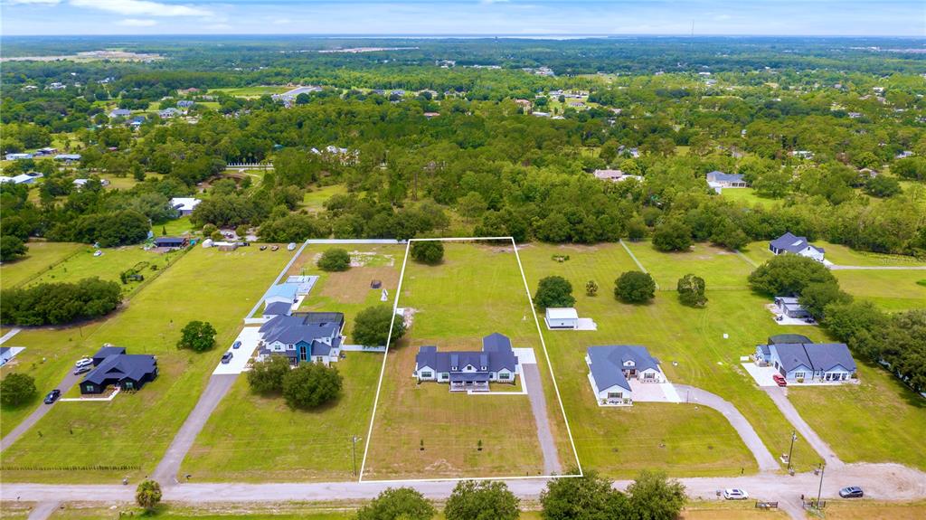 An aerial view shows a single-story house on a large, grassy lot with surrounding trees — 4230 TUCKER AVENUE, ST CLOUD, FL