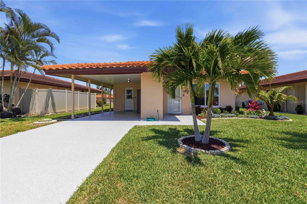 A single-story house with a carport, a tiled roof, and a palm tree in front — 3303 CAMBRIDGE AVENUE, BRADENTON, FL
