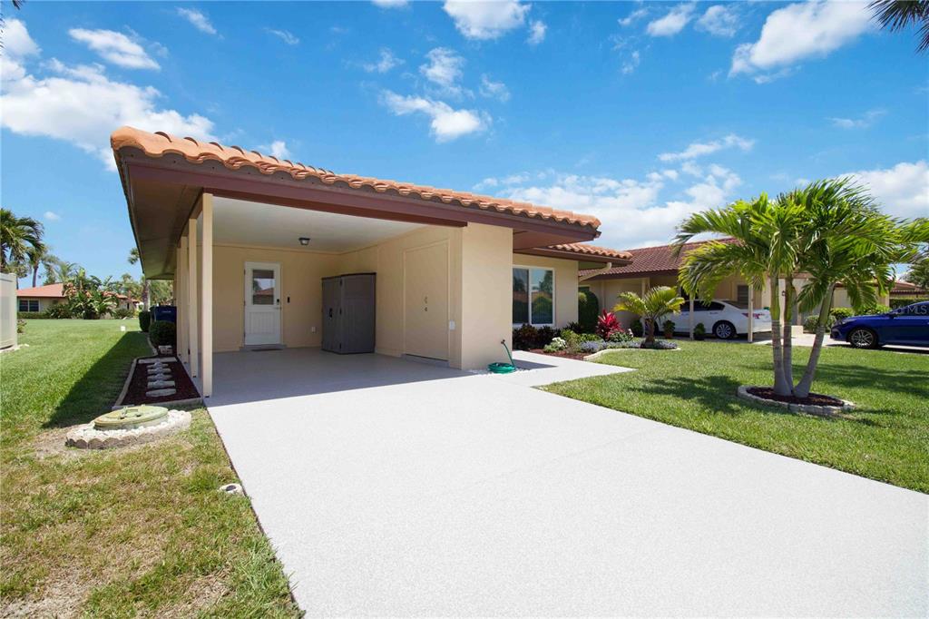 A single-story house with a carport, a tiled roof, and a concrete driveway — 3303 CAMBRIDGE AVENUE, BRADENTON, FL