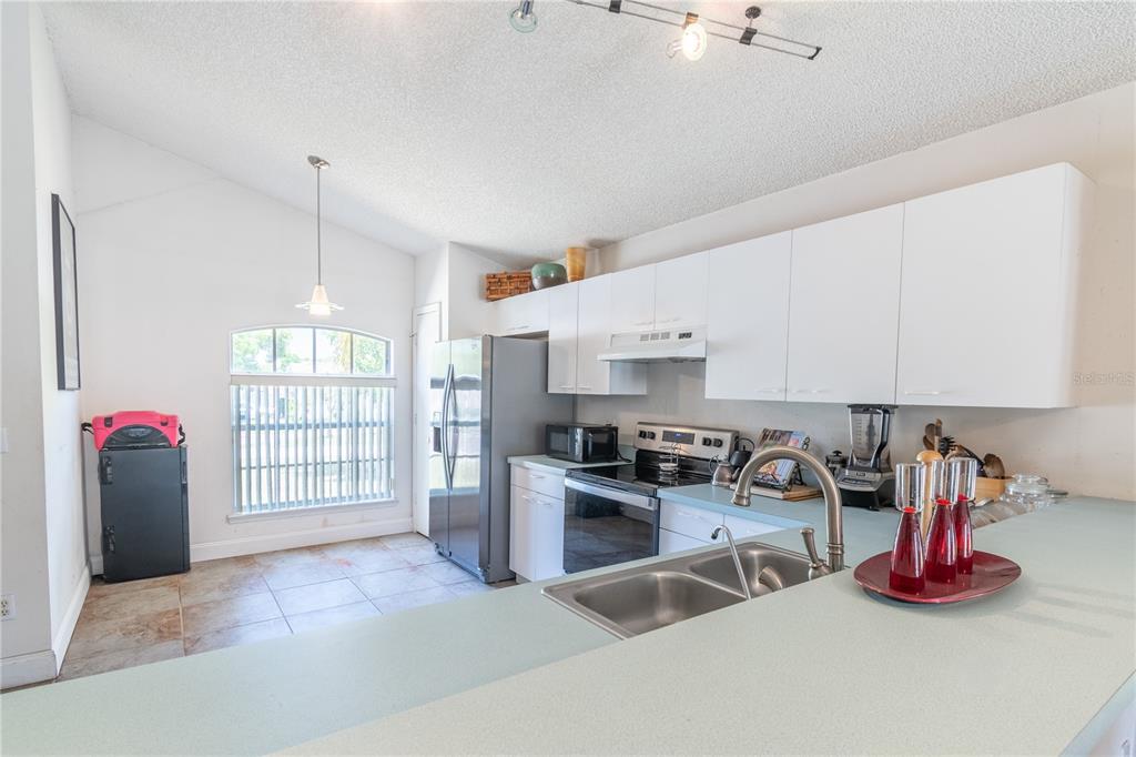A kitchen with white cabinets, a stainless steel refrigerator, and a light green countertop — 5501 CHATHAM WOODS COURT, ORLANDO, FL