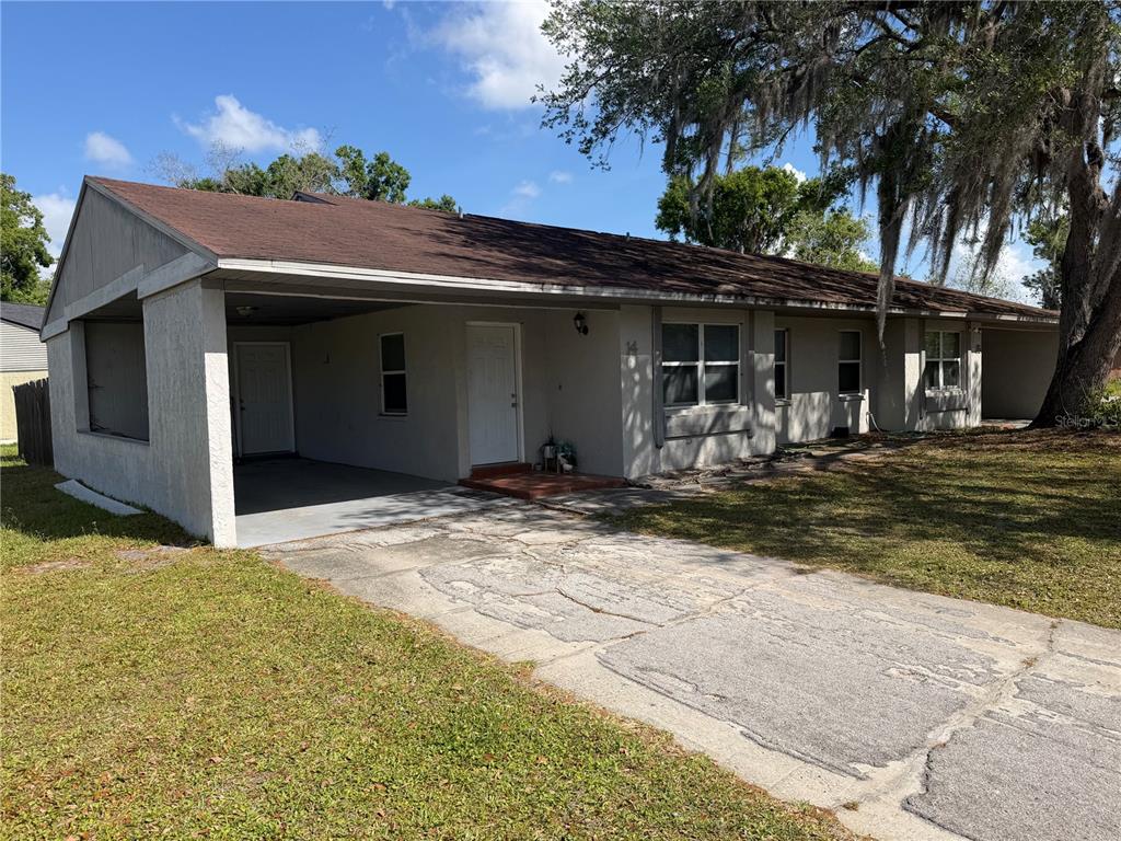 A single-story house with a carport, a concrete driveway, and a large tree in front — 2121 S SAN GULLY ROAD UNIT 14 - 15, LAKELAND, FL