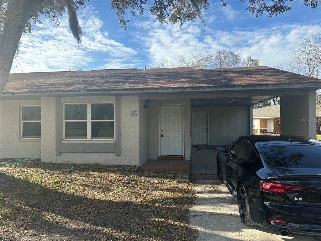 A single-story house with a carport, a white front door, and a black car parked outside — 2121 S SAN GULLY ROAD UNIT 14 - 15, LAKELAND, FL