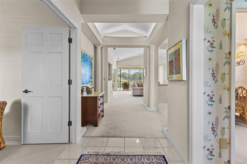 A tiled entryway leads into a carpeted living area with a tray ceiling and columns — 7726 CALLE FACIL, SARASOTA, FL