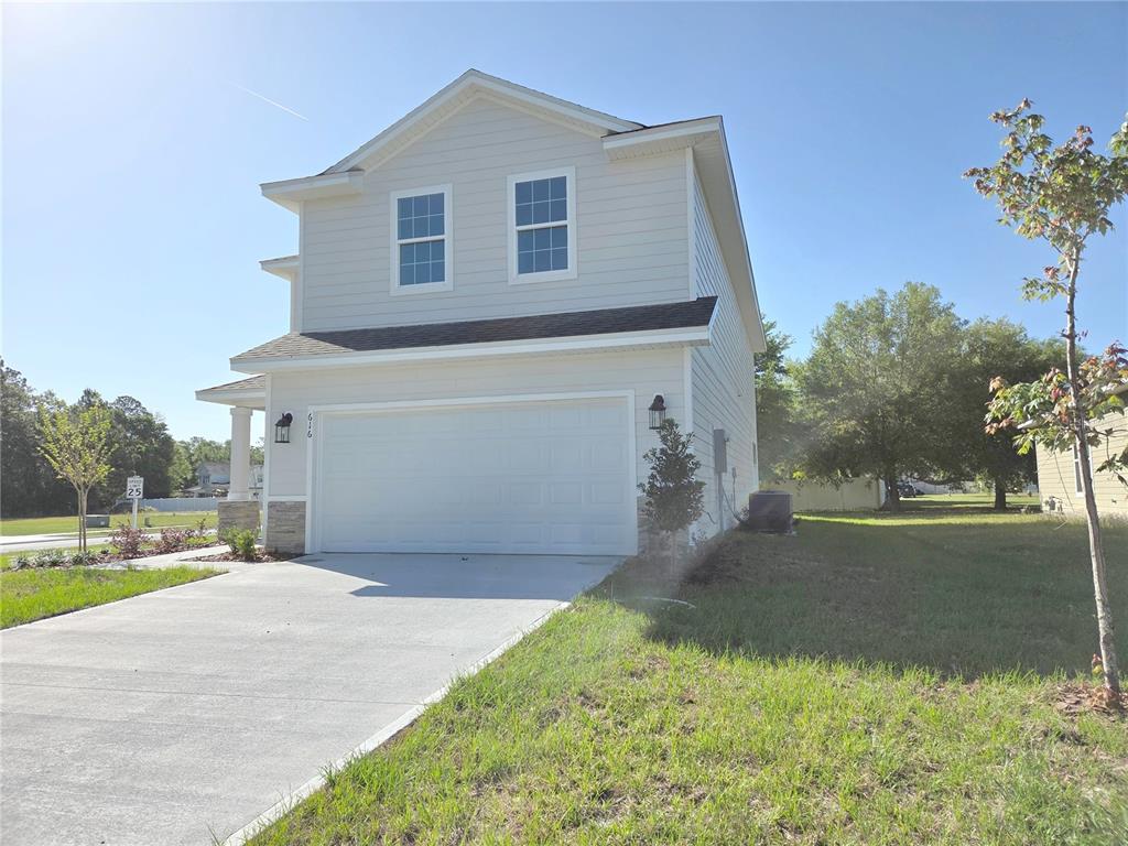A two-story house with light siding, a two-car garage, and a concrete driveway — 616 SW ROSEMARY DRIVE, LAKE CITY, FL
