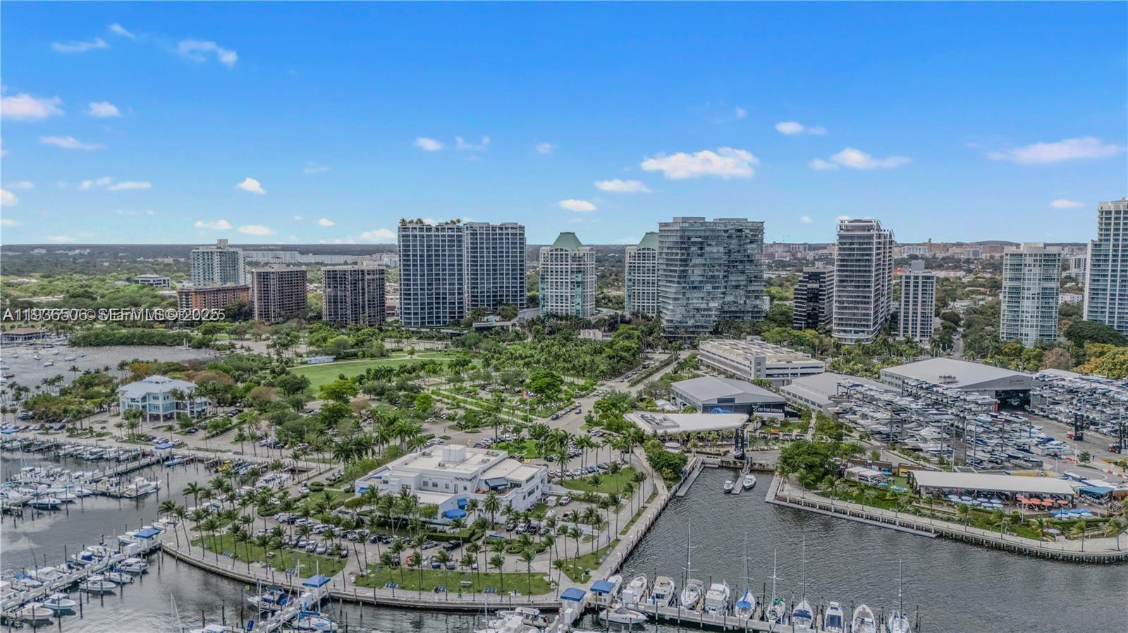 An aerial view shows a marina, a park, and several high-rise buildings under a blue sky — 3400 SW 27th Ave # 605, Miami FL 33133, MIAMI, FL