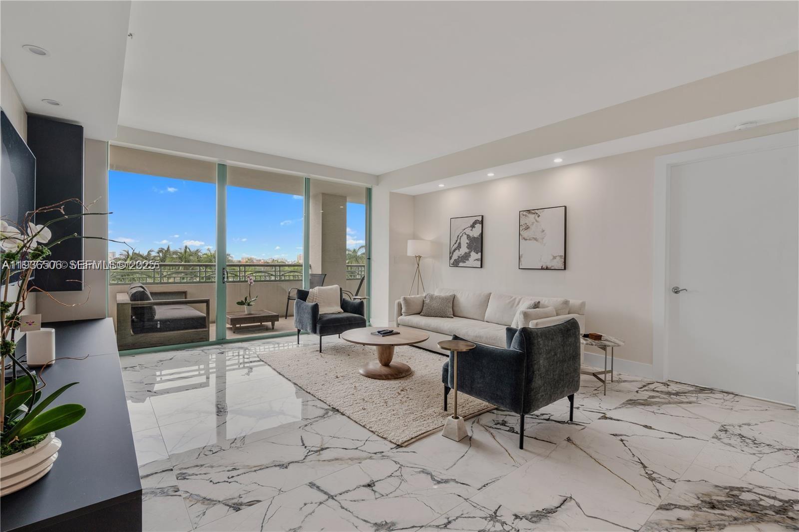 A modern living room features marble floors, a neutral sofa, two armchairs, and a balcony — 3400 SW 27th Ave # 605, Miami FL 33133, MIAMI, FL