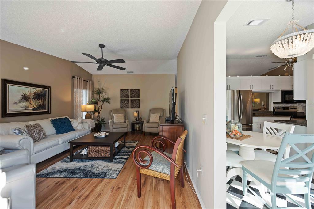 A living room with wood flooring and a ceiling fan opens to a dining area — 7206 29TH AVENUE DRIVE W UNIT 2263, BRADENTON, FL