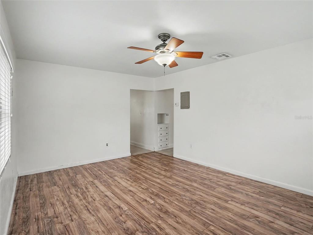An empty room with white walls, wood-look flooring, a ceiling fan, and a built-in cabinet — 1624 HAVEN DRIVE, ORLANDO, FL
