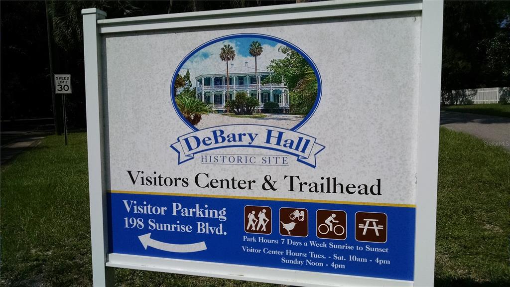 A sign for DeBary Hall Historic Site displays visitor information and park hours — 224 MANSION BOULEVARD, DEBARY, FL
