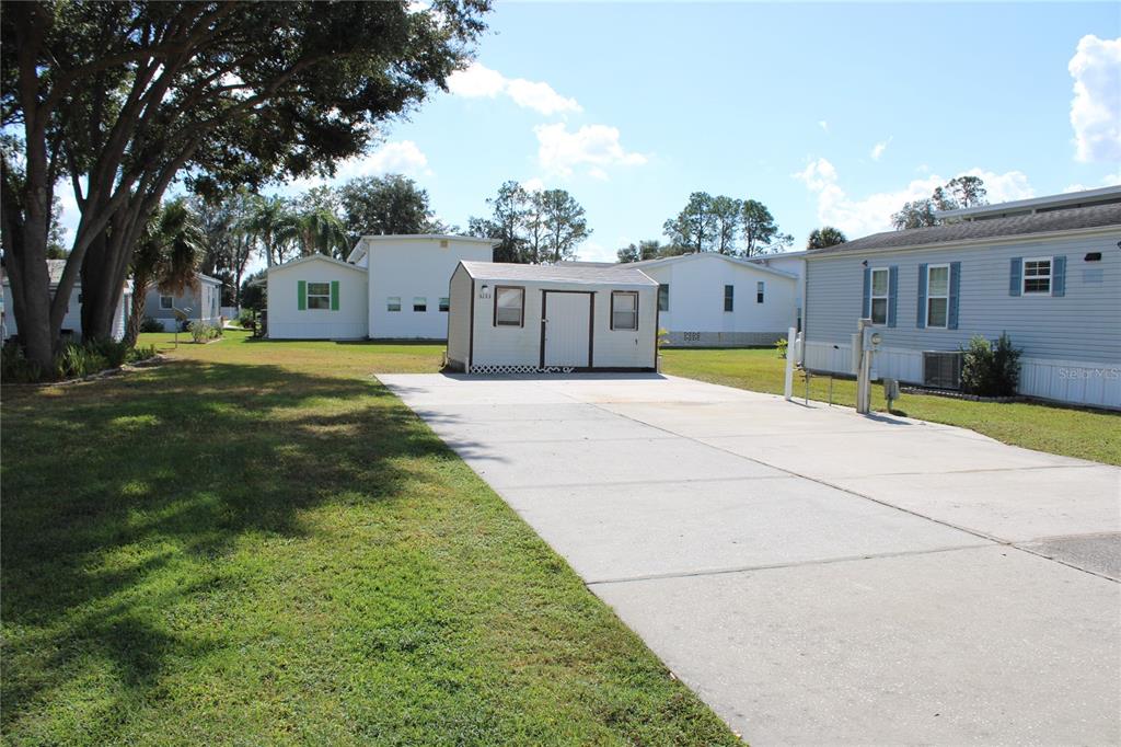 A concrete driveway leads to a small shed situated between two manufactured homes — 5133 SHORE LINE DRIVE, POLK CITY, FL
