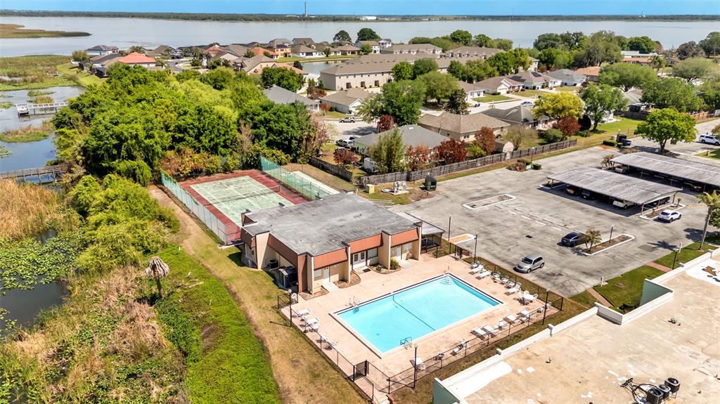 An aerial view shows a community clubhouse with a swimming pool and tennis court — 1130 N LAKE PARKER AVENUE UNIT C321, LAKELAND, FL