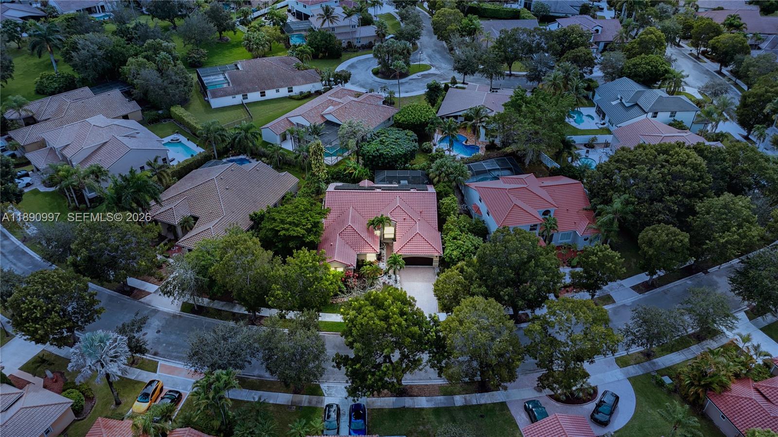 An aerial view shows a residential neighborhood with houses, swimming pools, and tree-lined streets — 523 Stonemont Dr, Weston FL 33326, WESTON, FL