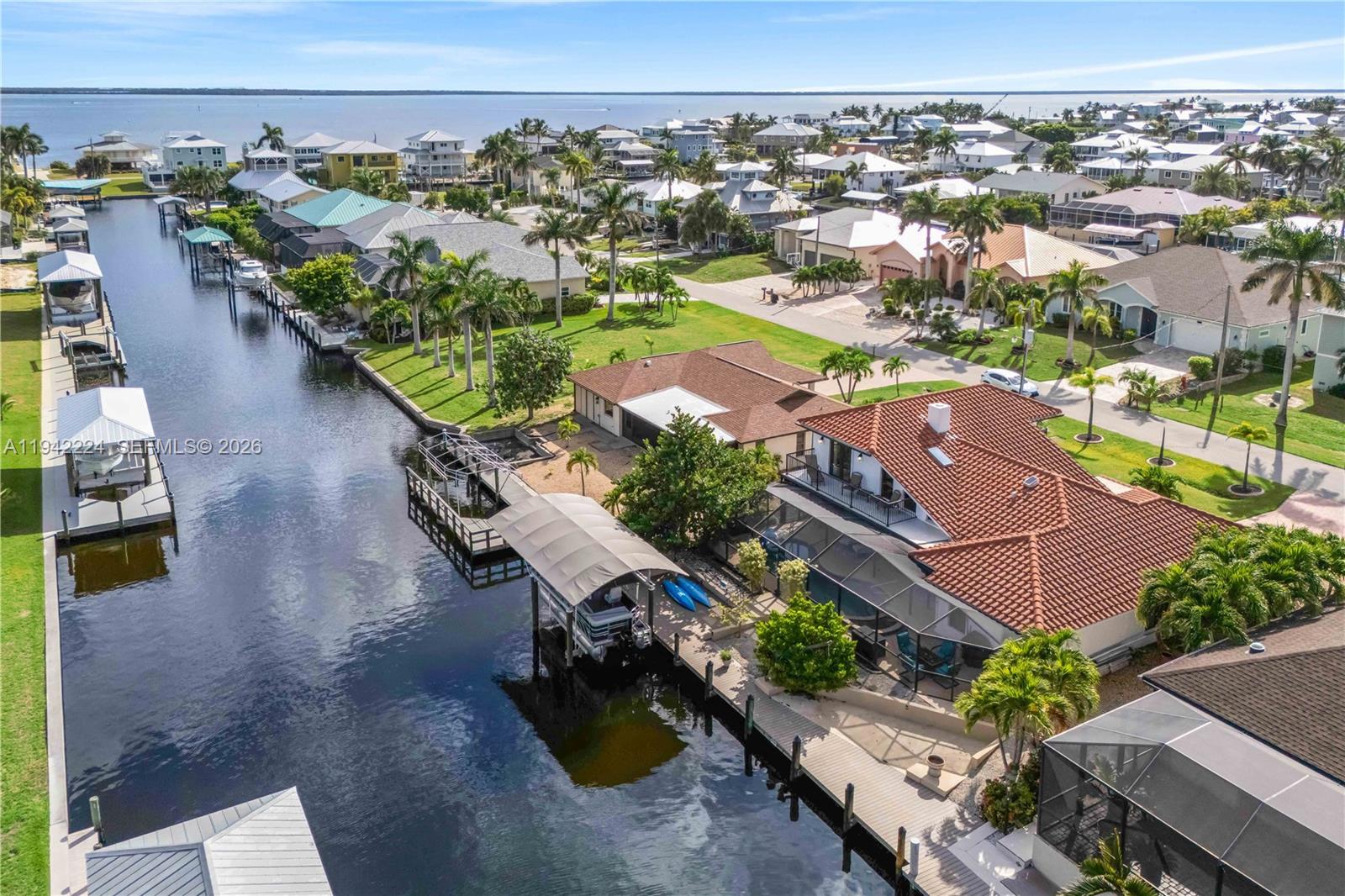 An aerial view shows a waterfront house with a boat dock and canal — OTHER CITY - IN THE STATE OF FLORIDA, FL