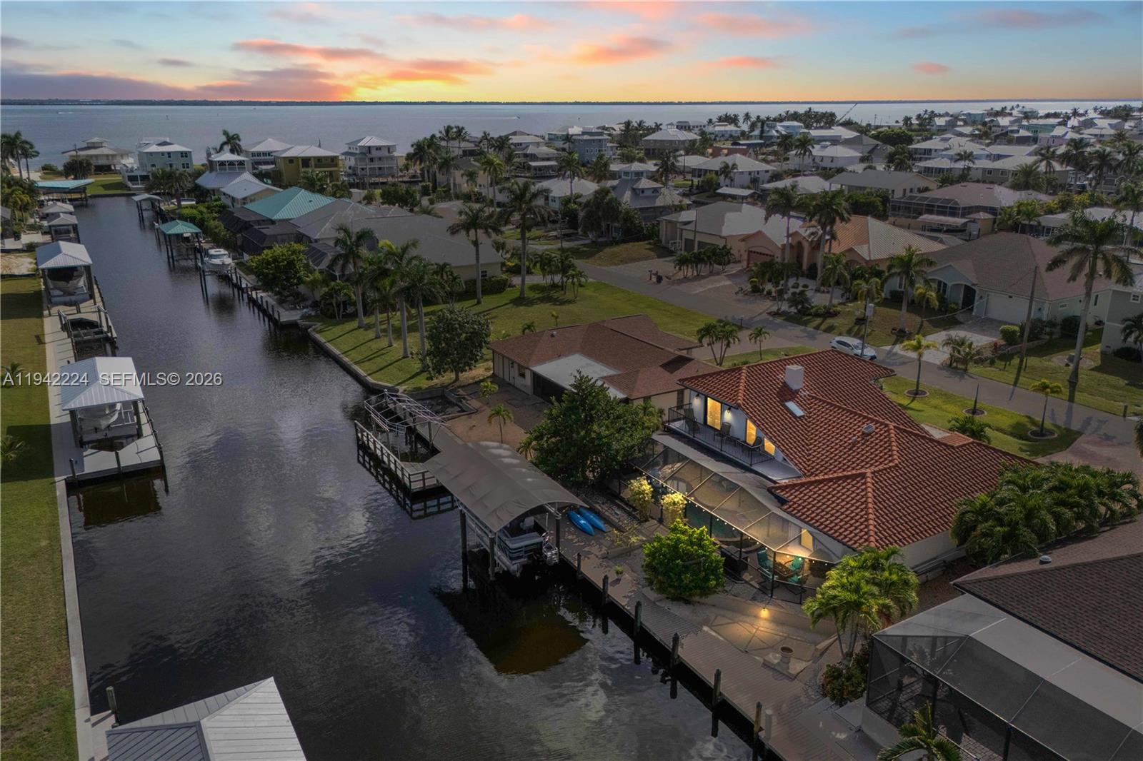 An aerial view shows a waterfront house with a tiled roof, pool, and boat dock — OTHER CITY - IN THE STATE OF FLORIDA, FL