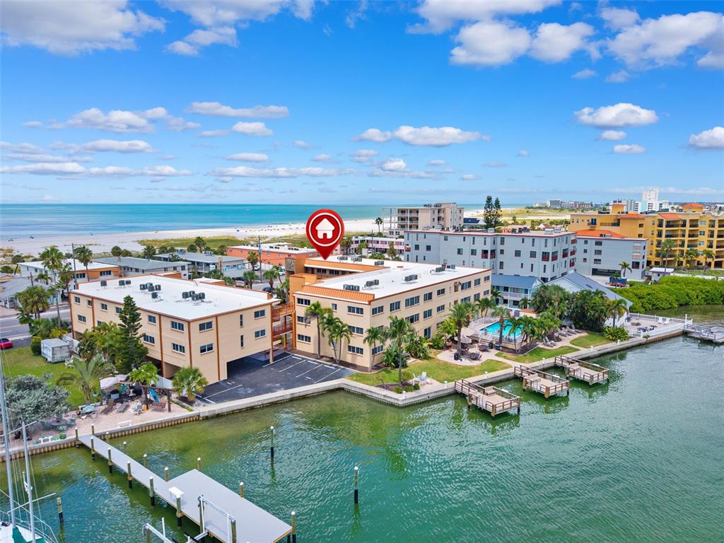 A living room features hardwood floors, a ceiling fan, a sofa, and a granite countertop — 10265 GULF BOULEVARD UNIT A-301, ST PETERSBURG, FL