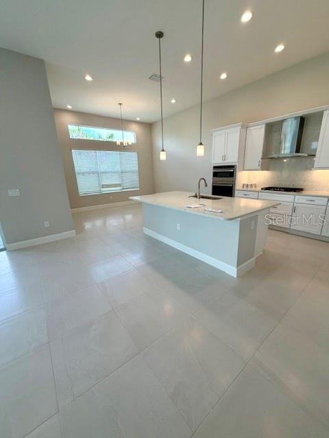 A long hallway features light-colored tile flooring, neutral walls, and a glass-paneled front door — 32630 NEROLI STREET, WESLEY CHAPEL, FL