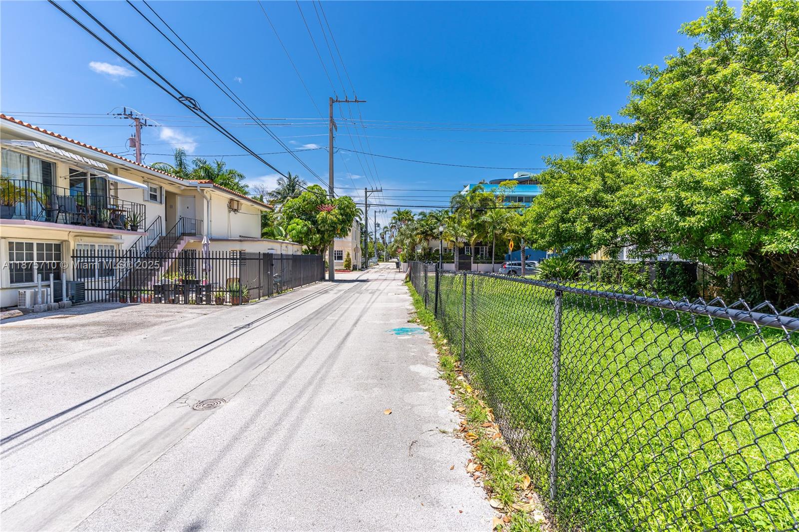 A paved alleyway runs between a residential building on the left and a fenced lot — 918 4th St, Miami Beach FL 33139, MIAMI BEACH, FL