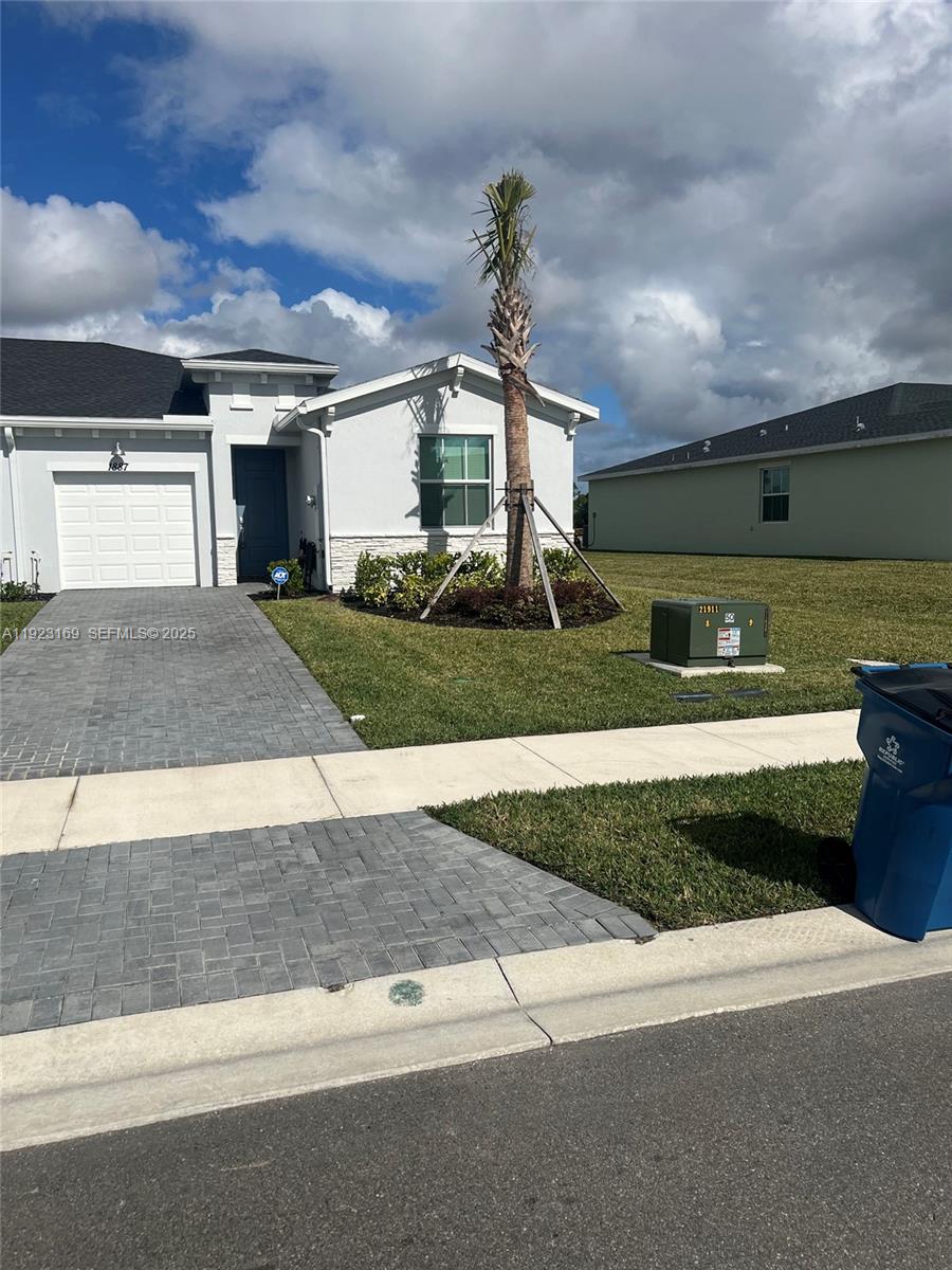 A single-story house with a paved driveway, a palm tree, and a green utility box — 1887 Cerulean Dr, Palm Bay FL 32907, PALM BAY, FL