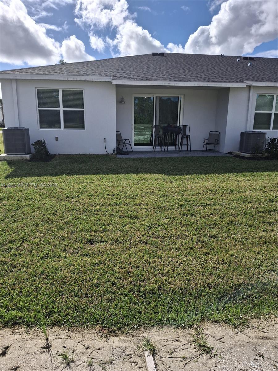 The exterior view shows the back of a house with a patio, sliding doors, and two air conditioning units — 1887 Cerulean Dr, Palm Bay FL 32907, PALM BAY, FL