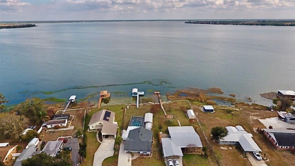 An elevated view of a backyard swimming pool enclosed by a white screen cage — 148 N LAKE REEDY BOULEVARD, FROSTPROOF, FL