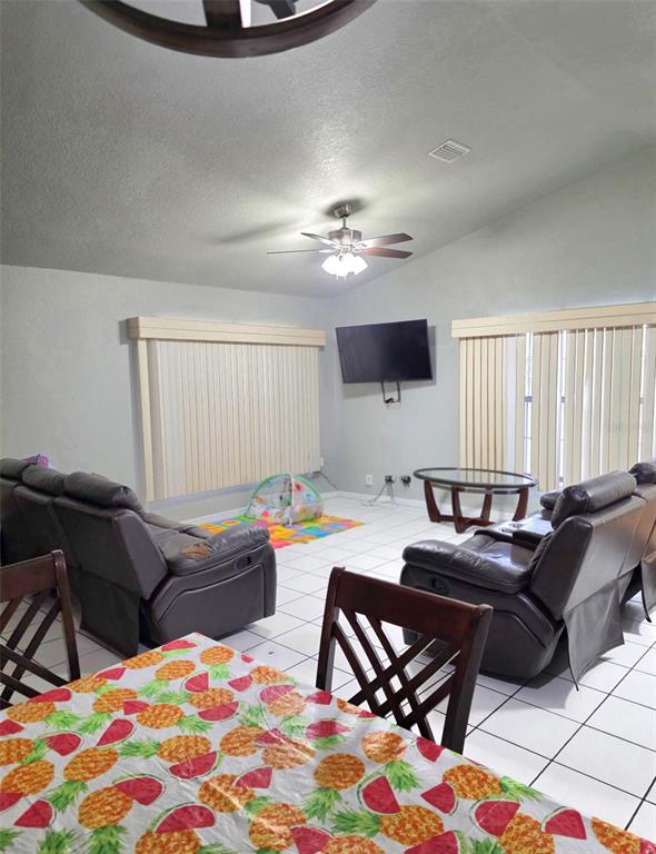 A living room features tile flooring, two brown leather recliners, and a wall-mounted television — 5419 SW 84TH PLACE, OCALA, FL