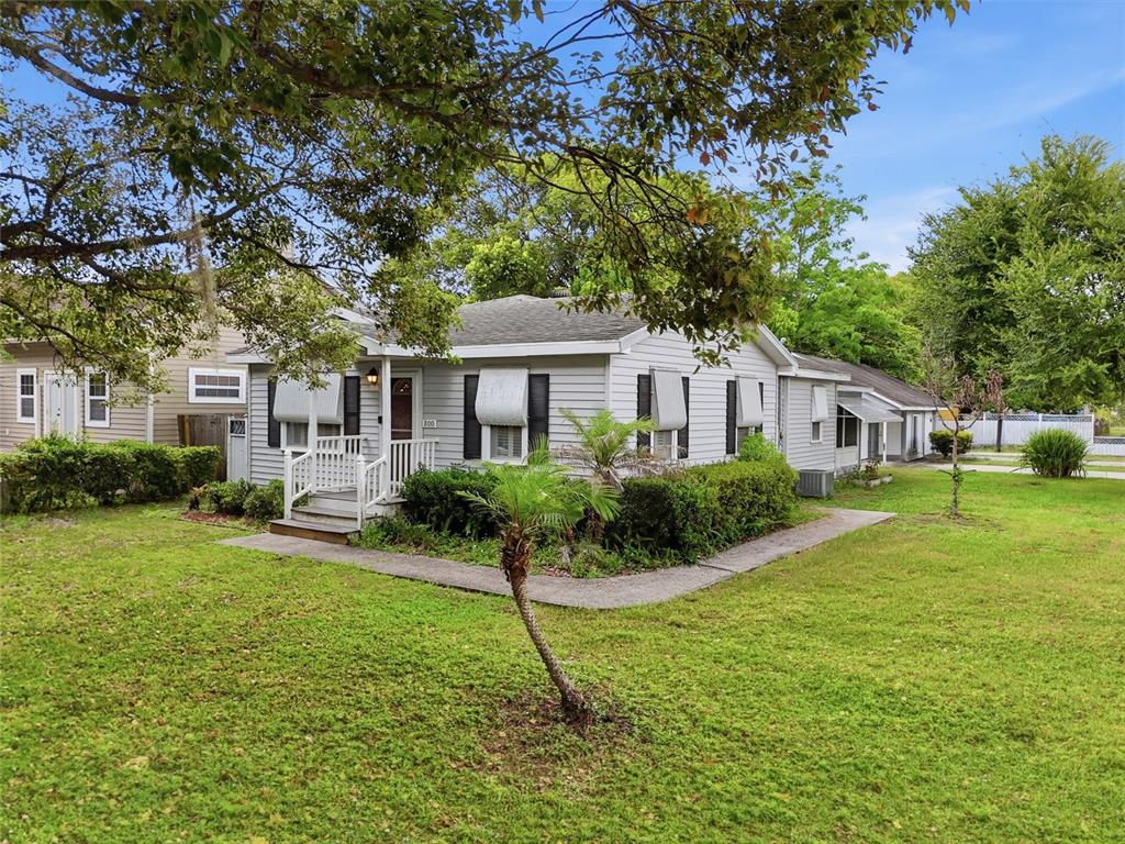 A single-story gray house with white trim and shutters sits on a grassy lawn — 800 VIRGINIA AVENUE, ST CLOUD, FL