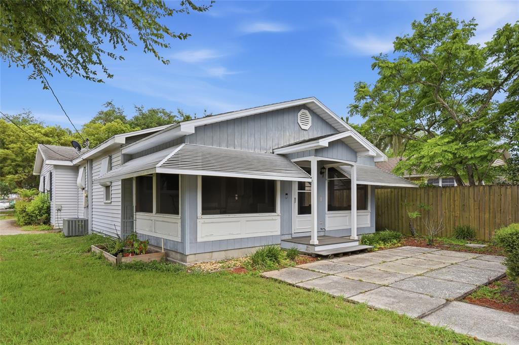 A light blue house with a screened-in front porch and a concrete patio — 800 VIRGINIA AVENUE, ST CLOUD, FL