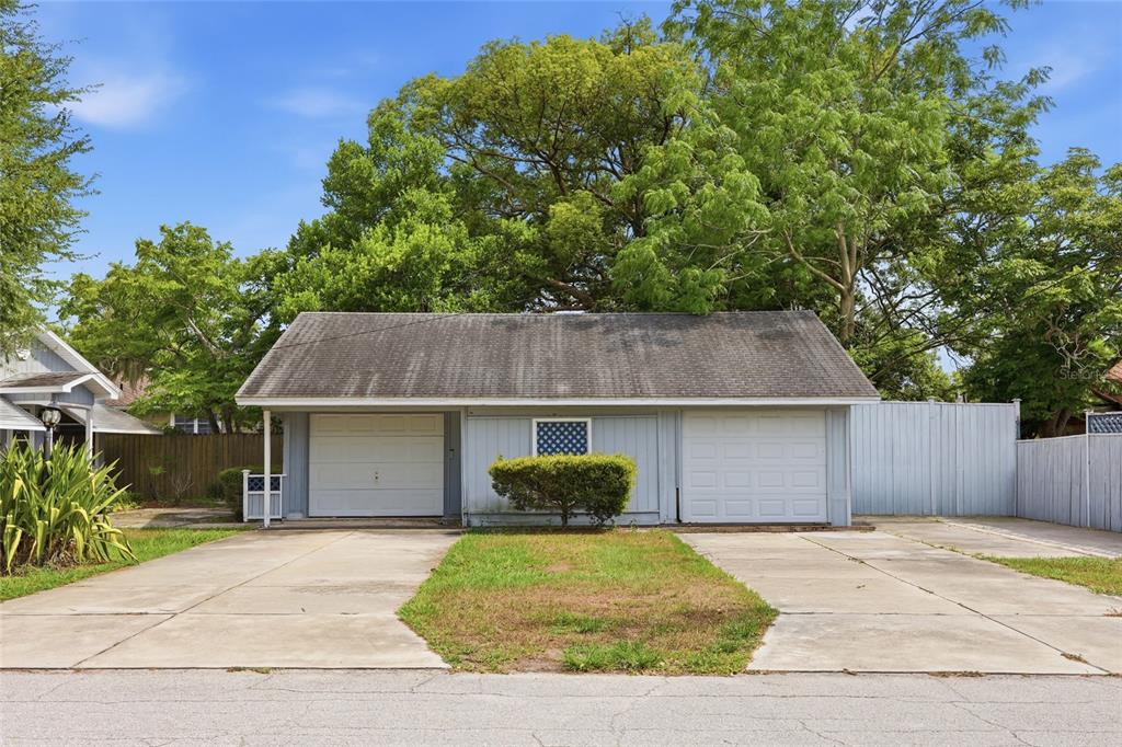 A detached two-car garage with a gray shingled roof and two white garage doors — 800 VIRGINIA AVENUE, ST CLOUD, FL