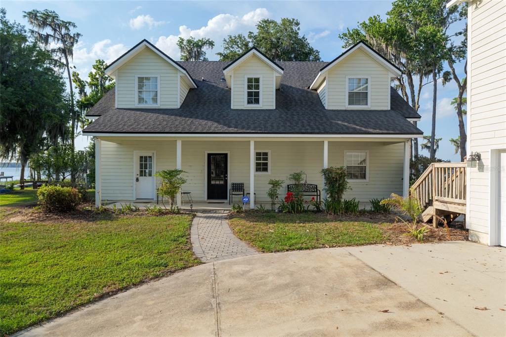 A two-story light yellow house with a covered porch and three dormer windows — 2499 SE 30TH STREET, MELROSE, FL