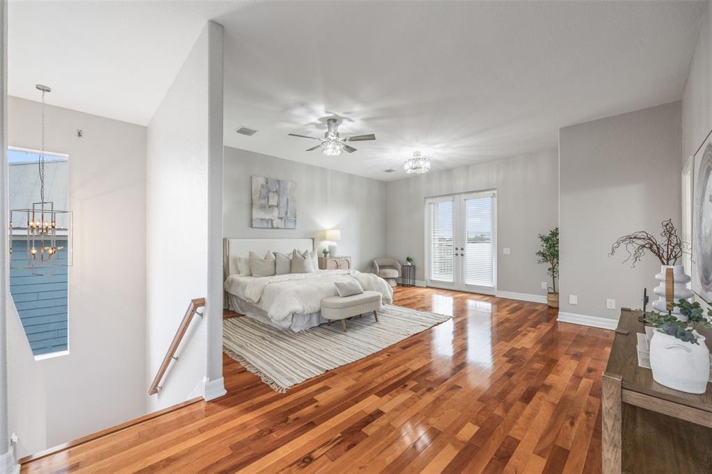 A spacious bedroom features hardwood floors, a ceiling fan, and double doors leading outside — 1340 APOLLO BEACH BOULEVARD S, APOLLO BEACH, FL
