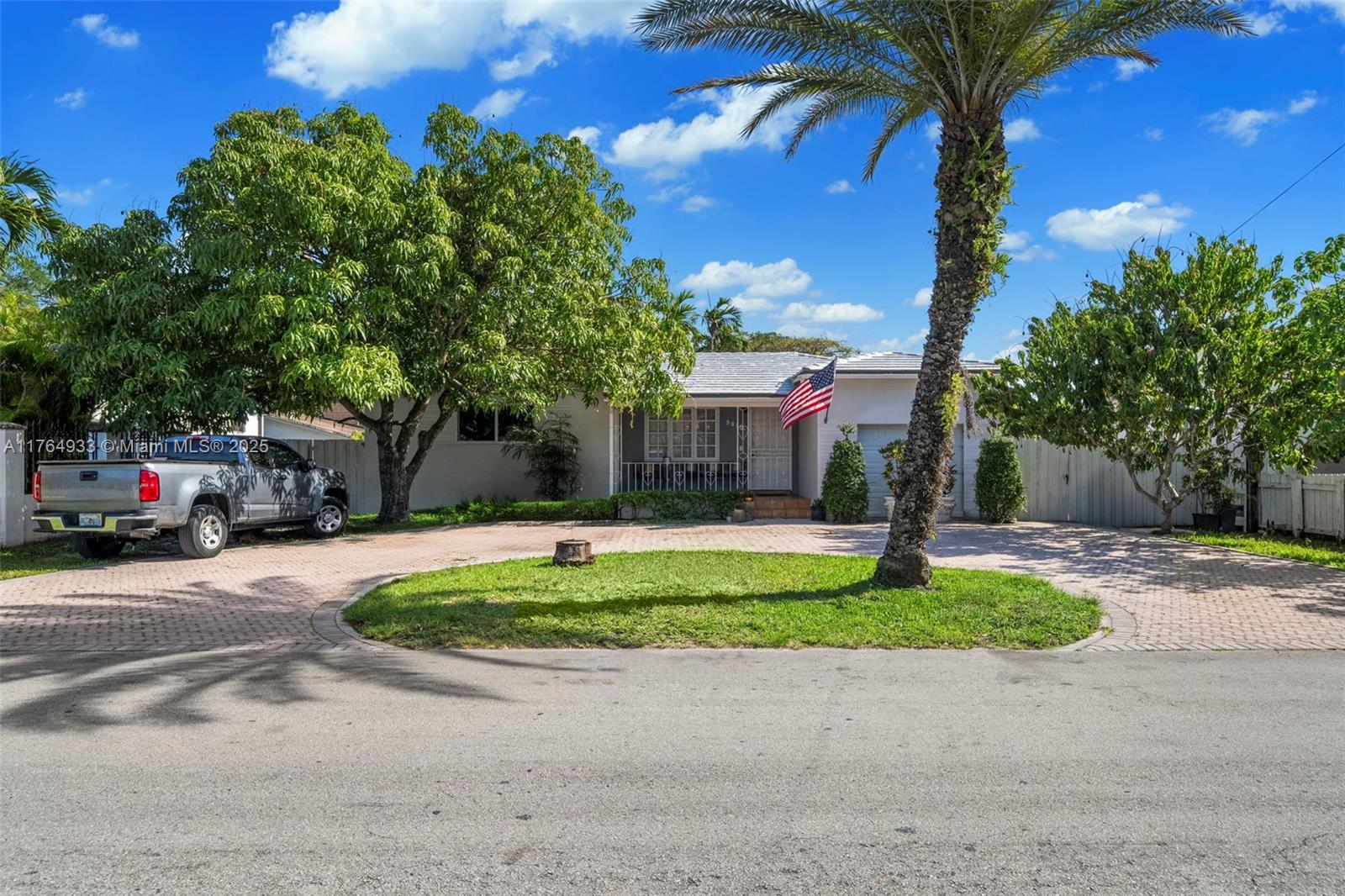 A single-story house with a circular driveway, palm tree, and American flag in the front — 5810 SW 22nd St, Miami FL 33155, MIAMI, FL