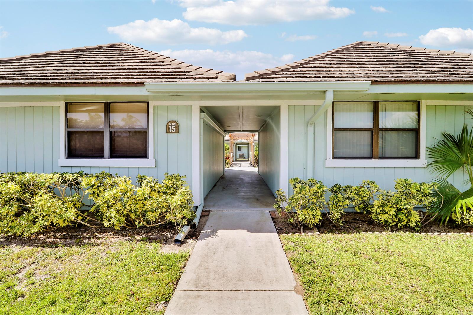 A light blue building with a central walkway and a brown tiled roof — 1127 E Seminole Avenue # 15b, Jupiter FL 33477, JUPITER, FL