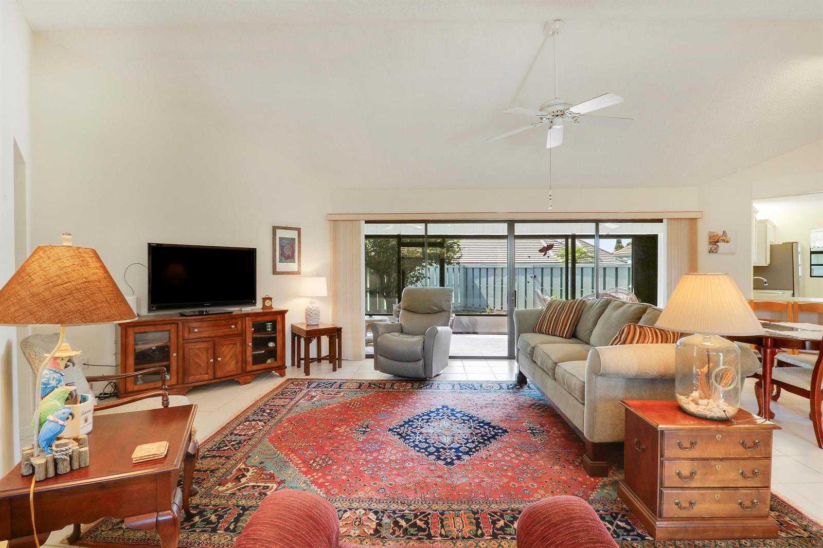 A living room features a large patterned rug, a sofa, a recliner, and a television — 1127 E Seminole Avenue # 15b, Jupiter FL 33477, JUPITER, FL
