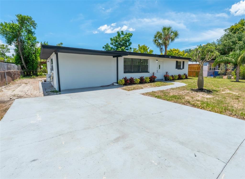 A single-story white house with a flat roof, dark trim, and a concrete driveway — 4112 W FAIRVIEW HEIGHTS, TAMPA, FL