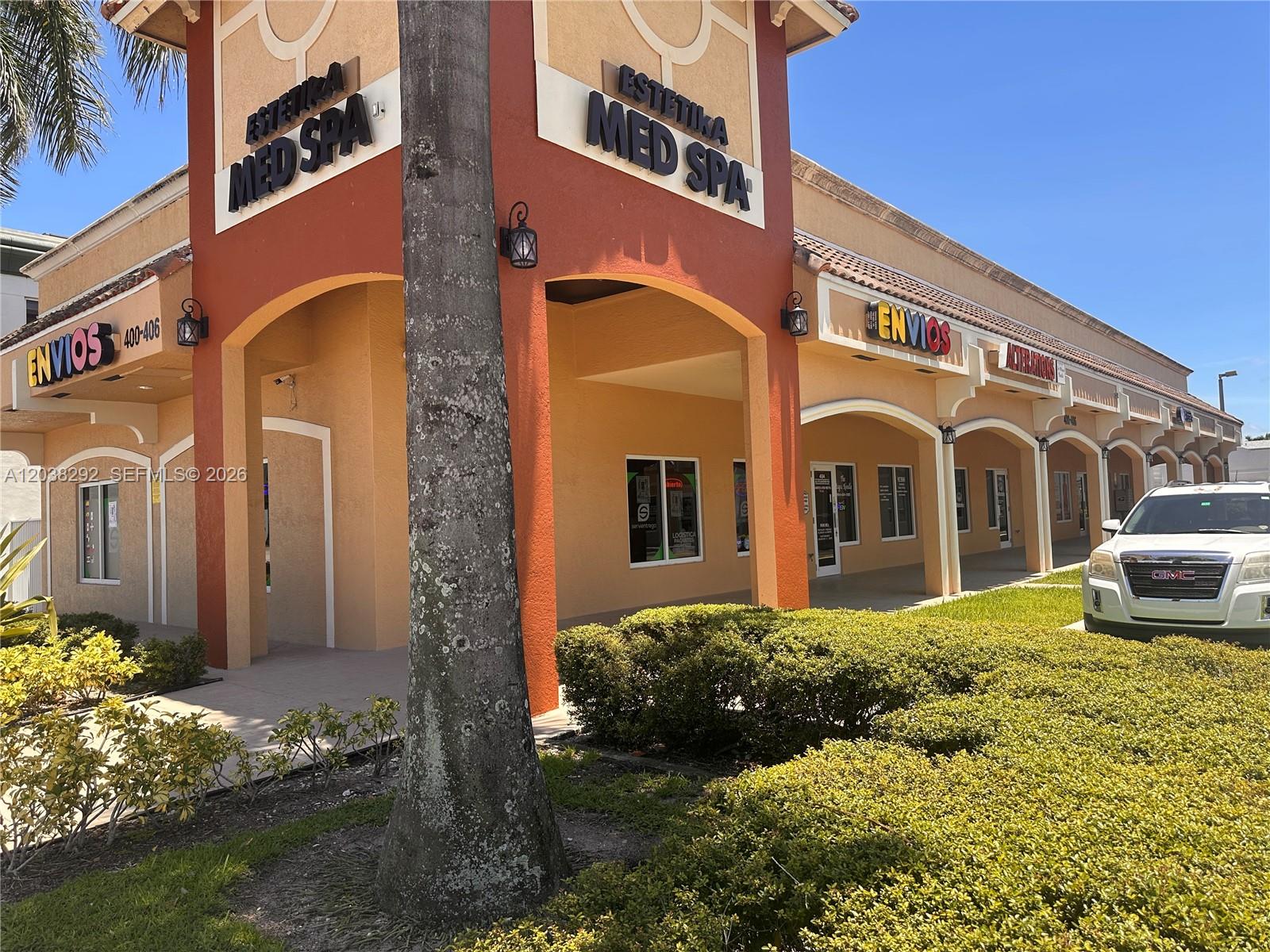 A commercial strip mall building features a Med Spa, shipping services, and a parked vehicle — 400 E Hallandale Beach Blvd, Hallandale Beach FL 33009, HALLANDALE BEACH, FL