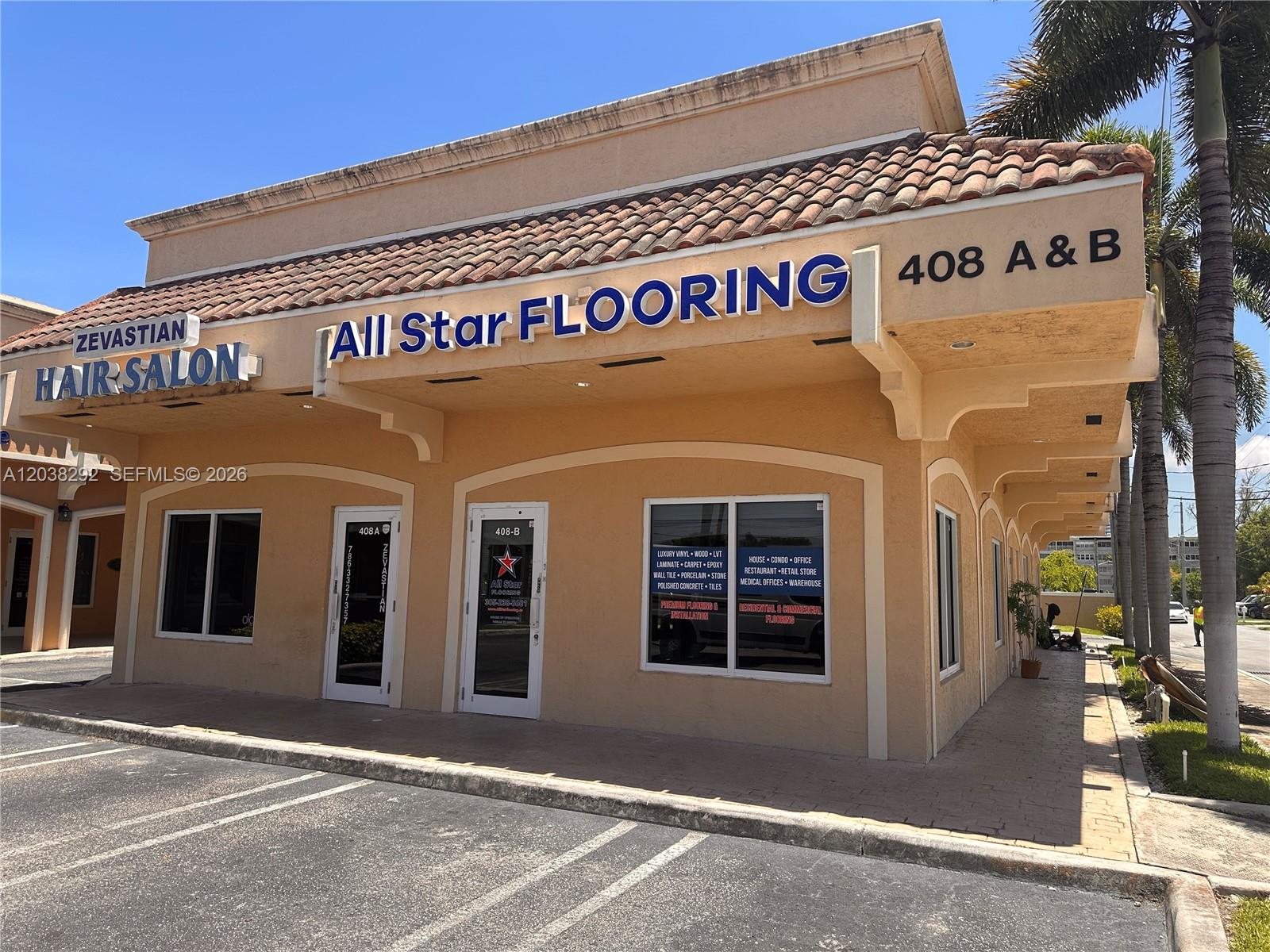 The exterior of a commercial building features a hair salon and a flooring store — 400 E Hallandale Beach Blvd, Hallandale Beach FL 33009, HALLANDALE BEACH, FL