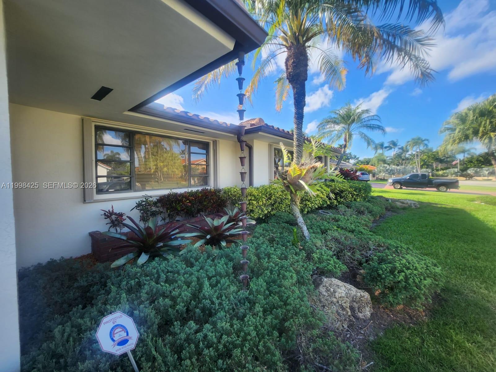A single-story house exterior features a rain chain, landscaping, and a palm tree — 2980 SW 111th Ave, Miami FL 33165, MIAMI, FL