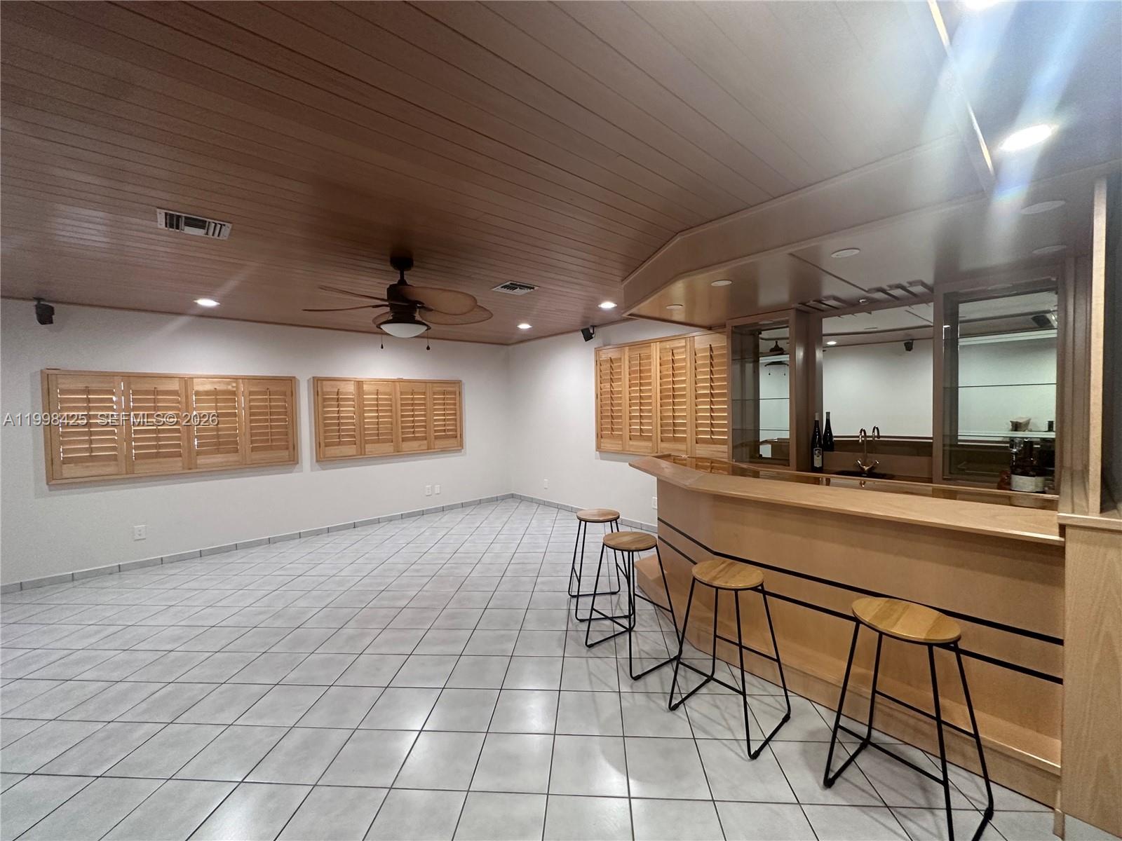 A room with a wooden ceiling, tiled floor, and a built-in bar with stools — 2980 SW 111th Ave, Miami FL 33165, MIAMI, FL