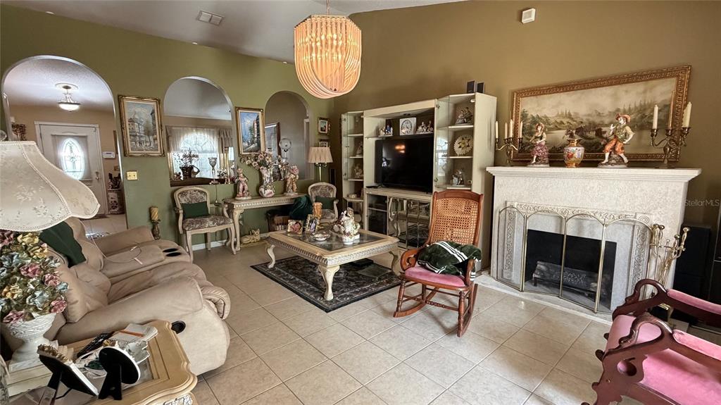 A living room features tile flooring, a fireplace, a television console, and arched wall openings — 3690 WELLINGTON PLACE, BARTOW, FL