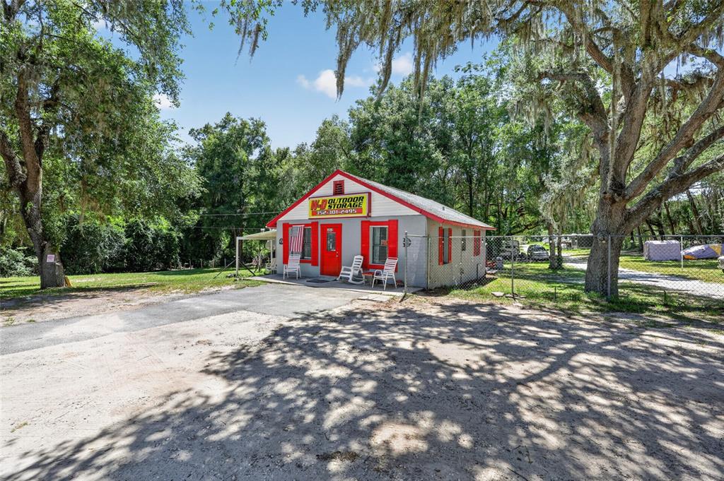 A small, grey, single-story building with red trim and a sign for outdoor storage — 3362 N CARL G ROSE HIGHWAY, HERNANDO, FL