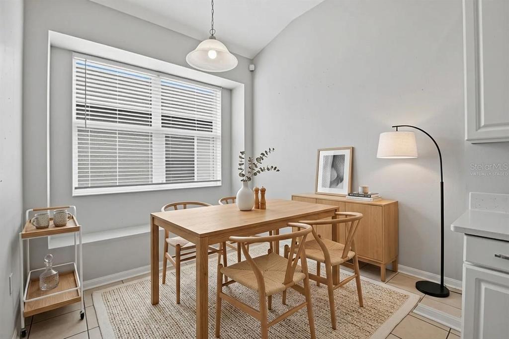 A dining room features a wooden table, chairs, a sideboard, and a large window — 427 FERN GULLEY DRIVE, SEFFNER, FL